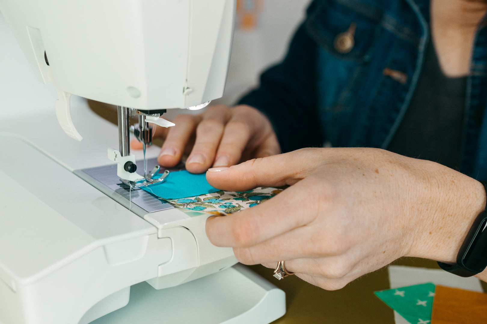 Westmoreland Place - hands guiding fabric on sewing machine